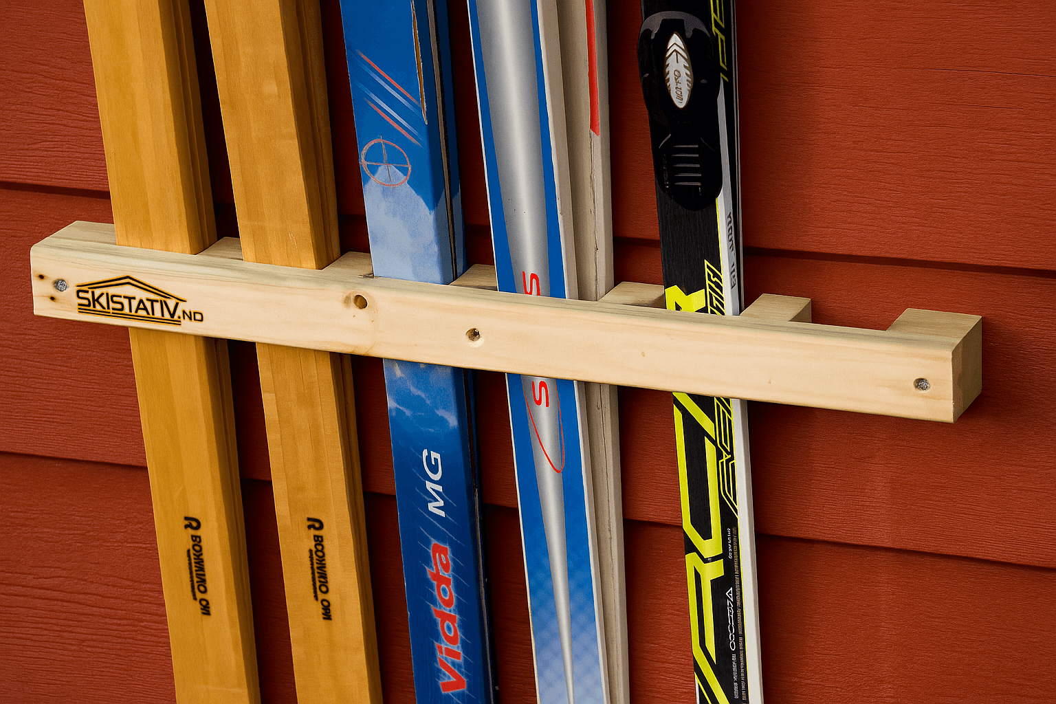 Skistativ med ski på rød vegg